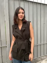 Chaleco marrón de lana merino, con cuello solapa, sin mangas y lazo para atar en la cintura.