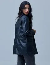 Blazer negro de eco cuero marca Baccini, con cuello con solapa, abertura central con botones y bolsillos delanteros.