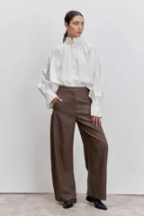 Camisa azul de manga larga con cuello alto fruncido y puños elásticos.