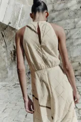 Vestido midi de cuello halter con diseño de cuadros, cintura elástica y abertura en la espalda. Cuenta con cierre de cremallera oculta y botón en la parte posterior.