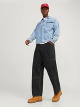 Pantalón de corte relajado y tiro medio, confeccionado en tejido canvas de algodón. Presenta costuras decorativas horizontales en las piernas y costuras a contratono, con cierre de cremallera y bolsillos funcionales.