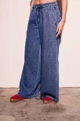 Pantalón de jean azul de tiro bajo y corte wide leg.