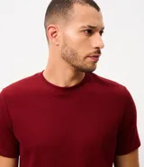 Remera de corte regular, color blanco crudo, con cuello redondo y mangas cortas. Presenta un diseño de textura perforada vertical y pertenece a la marca Marfinno.