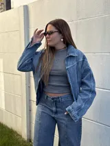 Campera de jean con diseño semi oversized, cuenta con bolsillos frontales y elástico en la espalda para un ajuste cómodo en la cintura.