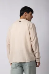 Camisa de manga larga confeccionada en tejido de lino con textura, de corte holgado y diseño versátil con cierre frontal de botones.