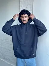 Buzo tipo canguro negro con capucha y cordones ajustables.