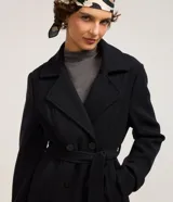 Saco negro confeccionado en polivelour con cuello solapa, doble botonadura frontal, bolsillos y cinturón para lazo en la cintura.