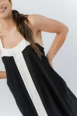 Vestido midi negro con panel frontal blanco, de corte amplio, escote recto y tiras anchas.