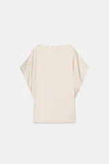 Top fluido de manga corta de Zara Woman Collection, confeccionado en hilatura de viscosa de color crudo. Cuenta con cuello barco, bajo recto y cierre en la espalda con pequeña abertura y botón.