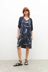 Vestido azul marino con estampado abstracto en blanco y celeste, escote en V y mangas cortas.