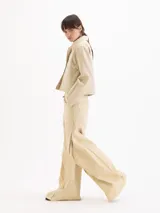 Chaqueta de gabardina color rosado con efecto desgastado, de calce relajado, cuello clásico marrón, bolsillos delanteros aplicados y cierre frontal con broches metálicos a presión.