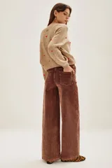 Pantalón de pana marrón, de corte wide leg, con tiro medio y bolsillos delanteros y traseros.