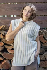 Chaleco tejido de punto acanalado vertical en color negro con hilos de lurex plateados. Presenta cuello redondo, hombros amplios con efecto de hombrera caída y tajos laterales en el ruedo.