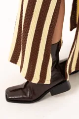 Pollera larga tejida a rayas verticales color chocolate y crema, con pretina elástica y tajos laterales.