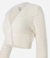 Cardigan cropped color crema con escote en V, manga larga y punto ondulado.