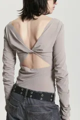 Top de manga larga color gris topo, ajustado al cuerpo, con escote barco y frunces laterales y en las mangas.