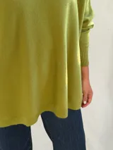 Sweater de punto color verde pistacho, con cuello redondo, mangas largas con puños ajustados y diseño holgado de corte oversize.