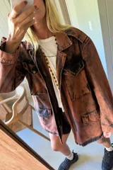 Parka de jean oversize con acabado lavado, cuello clásico, bolsillos frontales con tapa y cierre frontal. Presenta un diseño de silueta amplia y relajada con puños regulables.