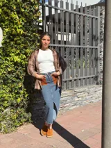 Falda midi de denim con elastano, corte recto y tajo frontal. Presenta bolsillos delanteros de cuero en color tostado y diseño clásico.