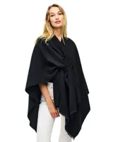 Ruana de tejido soft color negro, con cuello en V y un nudo o pasador frontal que ajusta la prenda. Los bordes tienen terminación desflecada.