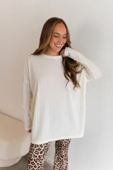 Conjunto de dos piezas compuesto por un buzo de cuello redondo y mangas largas con diseño holgado y un pantalón de corte recto y tiro alto. Ambas prendas están confeccionadas en tejido de punto acanalado.