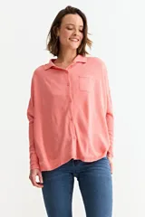 Cardigan de punto color crema, con cuello camisero, cierre frontal de botones y bolsillo frontal en el pecho.