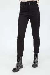 Jeans skinny negros de tiro alto, confeccionados en denim elastizado con diseño clásico de cinco bolsillos y doble botón en la cintura.