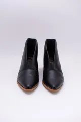 Botines de cuero color beige con diseño de tajo frontal, punta fina y taco cuadrado de madera.