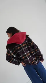 Buzo canguro oversize con capucha y cuello alto, confeccionado con paños de lana estampados.