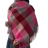 Bufanda rectangular de tejido afelpado con diseño de cuadros en tonos rosado, gris y beige. Presenta terminaciones con flecos en los extremos.