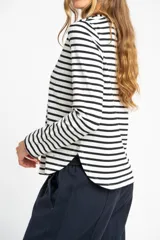 Remera de manga larga con diseño de rayas horizontales en blanco y negro, cuello redondo y corte ajustado al cuerpo.