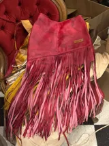 Pollera corta de cuero rojo con efecto marmolado, diseño asimétrico y larga cascada de flecos colgantes.
