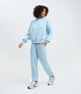 Pantalón jogger femenino de color celeste, confeccionado en mezcla de algodón y poliéster con felpa interior. Posee cintura con elástico, bolsillos laterales y puños ajustados en los tobillos.