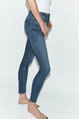 Jeans de corte skinny y tiro alto, confeccionados en tejido super elástico. Presentan diseño clásico de cinco bolsillos, cierre frontal con cremallera y botón metálico.