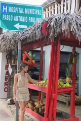Vestido corto de tejido de punto color beige, con escote profundo tipo halter y falda con volados en el frente.