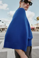 Jersey de punto liso color azul, con cuello redondo, botones delanteros y manga ancha por debajo del codo.