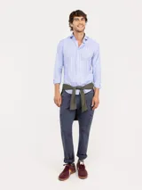 Camisa de manga larga confeccionada en algodón, con diseño de rayas verticales en tonos celeste y bordó. Presenta cuello italiano, cierre frontal con botones y logo bordado en el pecho.
