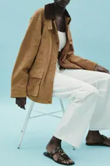 Sandalia plana color marrón con doble tira y hebilla metálica dorada.