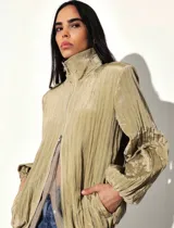 Campera liviana de acabado satinado con textura plisada, cuello alto, cierre frontal, bolsillos laterales, puños elastizados y cordón regulable en la cintura.
