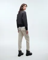 Pantalón tipo babucha sastrero negro, de tiro medio y corte pitillo hasta el tobillo. Presenta cintura elastizada, cartera falsa, bolsillos laterales y raya de aplomo en las piernas.