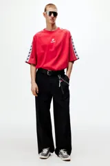 Remera de algodón oversized color rojo, con cuello redondo y mangas cortas raglán decoradas con una franja blanca lateral con logotipos negros de Lotto. Cuenta además con el logo de la marca estampado en el centro del pecho.