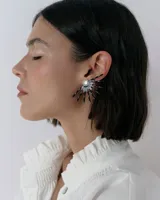 Caravanas tipo ear cuff con diseño de medio sol, compuestas por varillas metálicas plateadas, centro con strass y detalle de resina. Diseño liviano y brillante.