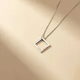 Collar de plata 925 con cadena fina de eslabones y dije geométrico en forma de cuadrado calado.