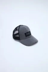 Gorra tipo trucker gris con visera curvada, paneles frontales de tela y paneles traseros de red negra. Cuenta con un parche rectangular negro con inscripción en el frente.