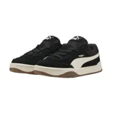 Championes Puma de estilo skate, color negro con la franja lateral característica en blanco. Presentan una suela de plataforma blanca con base de goma color caramelo.