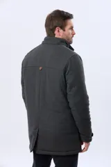 Saco de paño color gris oscuro, con capucha desmontable, cierre frontal oculto por cartera con botones a presión y bolsillos laterales. Presenta un diseño de abrigo estructurado con forro interior.