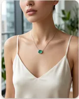 Collar de plata con cadena fina de eslabones y un dije ovalado con piedra natural turmalina de color verde.