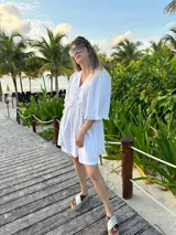 Vestido corto verde manzana de lino, con escote en V con volados y mangas abullonadas.