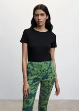 Pantalón de vestir de corte skinny con estampado floral en tonos verde claro y verde oscuro. Presenta tiro medio, trabillas para cinturón, cierre con cremallera y botón, y bolsillos laterales y traseros. Confeccionado en tejido fluido con forro interior.