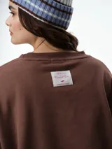 Buzo de cuello redondo y manga larga, con diseño oversize y corte relajado. Presenta puños y ruedo acanalados, confeccionado en tejido de textura suave.